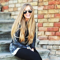 Stylish smiling woman in sunglasses - close up