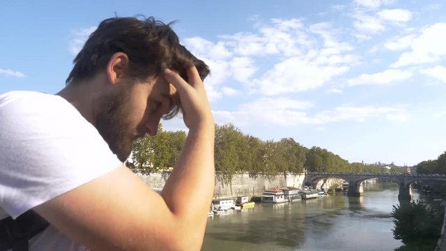 Young Male Looking Out Over River Landscape In European City.