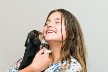 Obraz premium Cute teenage girl hugging a beagle puppy. Cute young woman with a puppy dog.