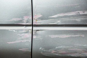 Car doors scratched during an accident, close-up damage to the paintwork of the car.