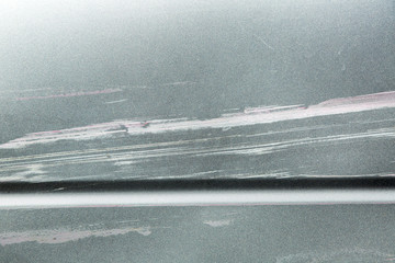 The damaged body part of the car after the accident, the scratched paintwork surface of the car.