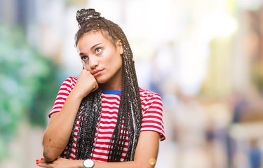 Young braided hair african american girl over isolated background with hand on chin thinking about question, pensive expression. Smiling with thoughtful face. Doubt concept.