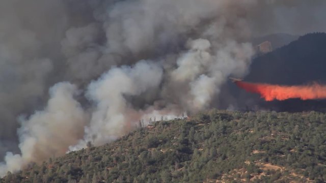 Airplane dropping retardant on a raging California wildfire