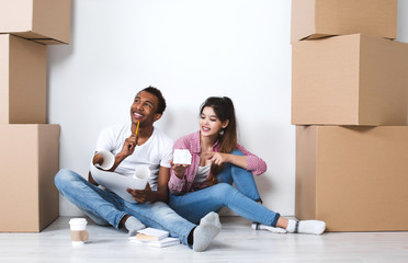 Happy young couple sitting on floor dreaming of a new home.