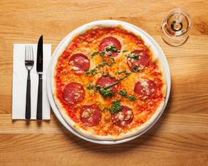 Authentic Italian Pizza, Salami - Delicious, fresh Pizza, beautifully arranged on a wooden table