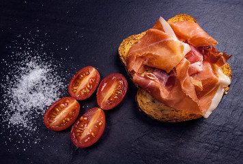 APERITIVO TÍPICO ESPAÑOL DE PAN CON JAMÓN IBÉRICO TOMATE Y SAL
