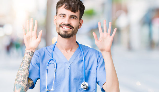 Young handsome nurse man wearing surgeon uniform over isolated background showing and pointing up with fingers number ten while smiling confident and happy.