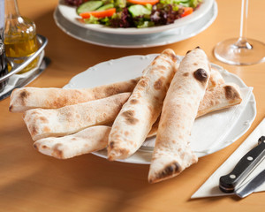 Close up view of pizza bread sticks - beautifully arranged and served on a wooden table