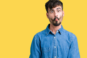 Obraz premium Young handsome man over isolated background making fish face with lips, crazy and comical gesture. Funny expression.