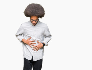 Young african american man with afro hair wearing glasses with hand on stomach because indigestion,...
