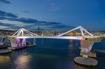  Port Vell with its bridge Porta d'Europa and the aerial tramway tower Torre Jaume I in Barcelona...