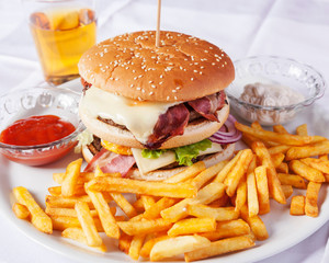 American burger with fries on white background served outside on a sunny day