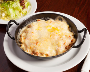 Böhmische Küche, Schinkenfleckerl - Angerichtet in einer Pfanne auf einem Holztisch