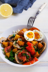 Smoked salmon breakfast bowl with egg, potatoes, mushrooms and rice