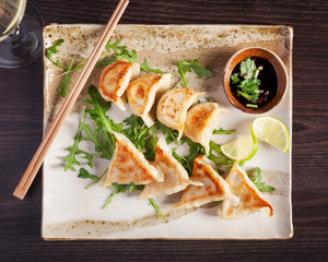 Close up top view of authentic Gyoza - steamed buns beautifully arranged and served on a dark wooden table