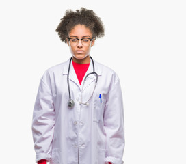 Young afro american doctor woman over isolated background skeptic and nervous, frowning upset because of problem. Negative person.