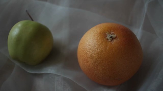 Orange and green apple. Short pan