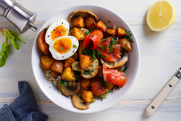 Smoked salmon breakfast bowl with egg, potatoes, mushrooms and rice. View from above, top studio shot