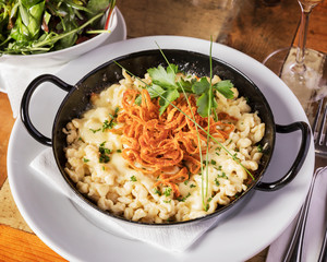 Böhmische Küche, Kasnockerl - Köstliche Käsenockerl ngerichtet in einer Pfanne auf Holztisch