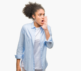 Young afro american woman over isolated background shouting and screaming loud to side with hand on mouth. Communication concept.