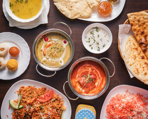 Indian food, top down view -  Delicious mixed oriental dishes, beautifully arranged and surved on a wooden table