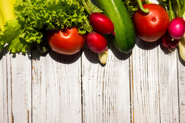 Tomato, zucchini, pepper, onion, radish - vegetables on wooden table, background