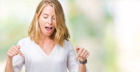 Beautiful young elegant woman over isolated background Pointing down with fingers showing advertisement, surprised face and open mouth