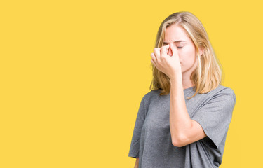 Beautiful young woman wearing oversize casual t-shirt over isolated background tired rubbing nose and eyes feeling fatigue and headache. Stress and frustration concept.