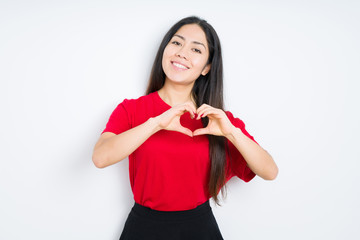 Fototapeta premium Beautiful brunette woman wearing red t-shirt over isolated background smiling in love showing heart symbol and shape with hands. Romantic concept.