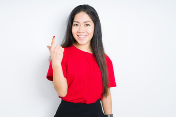 Beautiful brunette woman wearing red t-shirt over isolated background Beckoning come here gesture with hand inviting happy and smiling