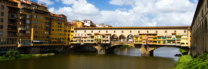 Fototapeta na wymiar The Shopping Bridge - Colorful Ponte Vecchio - a bridge hosting many jewelry shops - crosses the River Arno. Florence, Italy