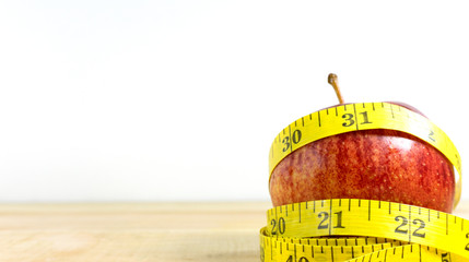 lunch time now. Healthy diet food concept,  apple red and measuring tape.
