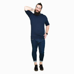 Fototapeta premium Young hipster man with long hair and beard wearing glasses Suffering of neck ache injury, touching neck with hand, muscular pain