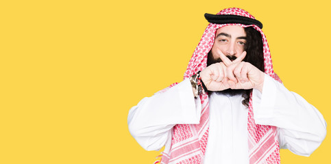 Arabian business man with long hair wearing traditional keffiyeh scarf Rejection expression crossing fingers doing negative sign