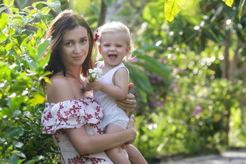 Portrait of happy mother with her baby girl in the park during a nice summer day