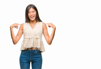 Young asian woman over isolated background looking confident with smile on face, pointing oneself...