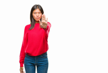 Young asian woman wearing winter sweater over isolated background doing stop sing with palm of the hand. Warning expression with negative and serious gesture on the face.