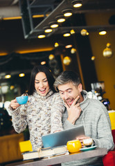 Smiling couple using digital tablet in cafe