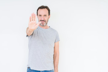 Handsome senior man over isolated background doing stop sing with palm of the hand. Warning expression with negative and serious gesture on the face.