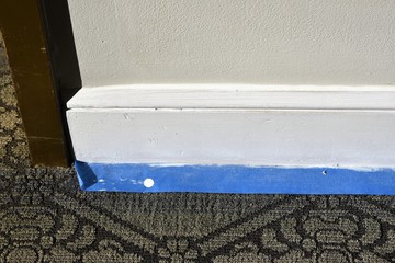 Blue painters tape on baseboard