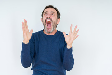 Elegant senior man over isolated background crazy and mad shouting and yelling with aggressive...
