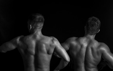 Fototapeta na wymiar Two bodybuilders isolated on balck background