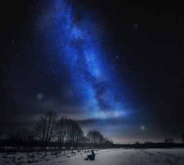 Fototapeta na wymiar Dreamy surreal landscape with starry night sky and man silhouette.