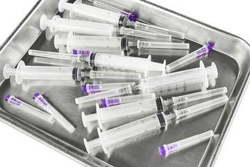 Metal salver with syringes and needles. Isolated on white background