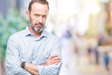 Fototapeta premium Middle age hoary senior business man over isolated background skeptic and nervous, disapproving expression on face with crossed arms. Negative person.