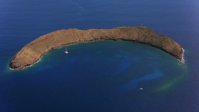 Maui, Hawaii circa-2018.  Aerial view of Molokini Crater off the coast of Maui.  Shot with Cineflex and RED Epic-W Helium. 
