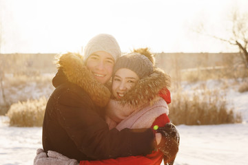 Obraz premium Enamored teenagers on date in winter. Guy and girlfriend hug each other and smile. Joy of being together. First love. Concept for Valentine's Day.