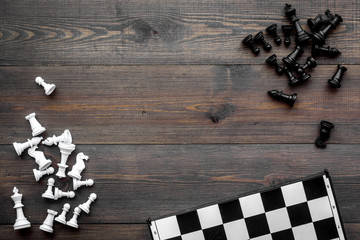 Competition or victory or strategy concept. Chess board and chess figures on dak wooden background top view copy space