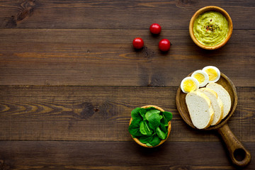 Healthy breakfast. Toasts with vegetables and guacamole on dark wooden background top view copy space