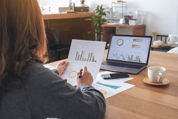 A businesswoman writing and working on business data and document with laptop on the table in office